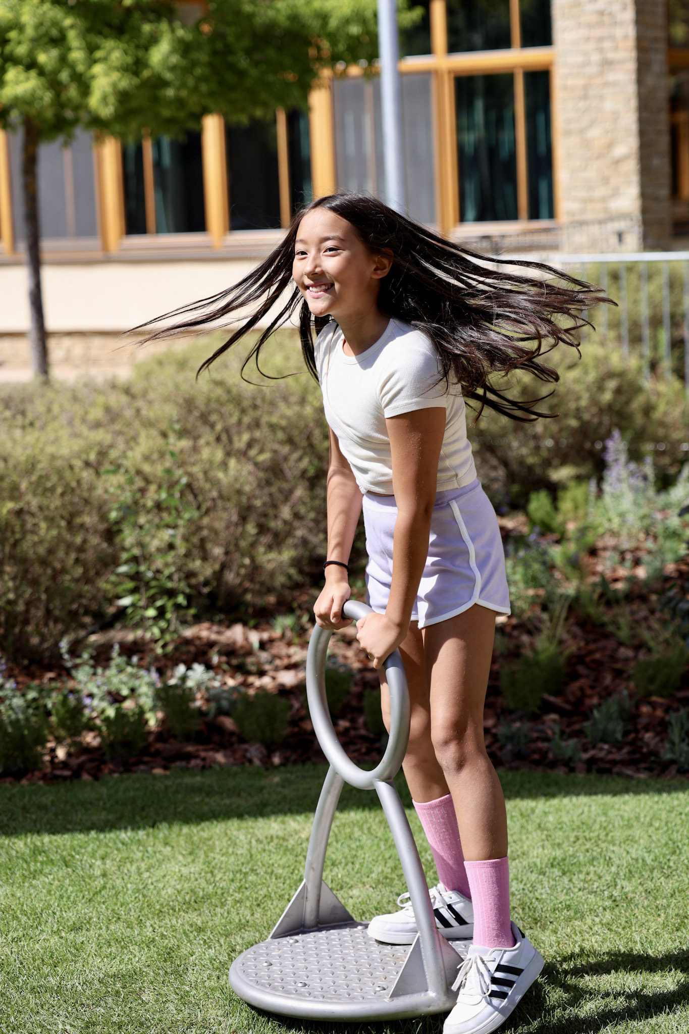 Student spinning on a toy in the new playground