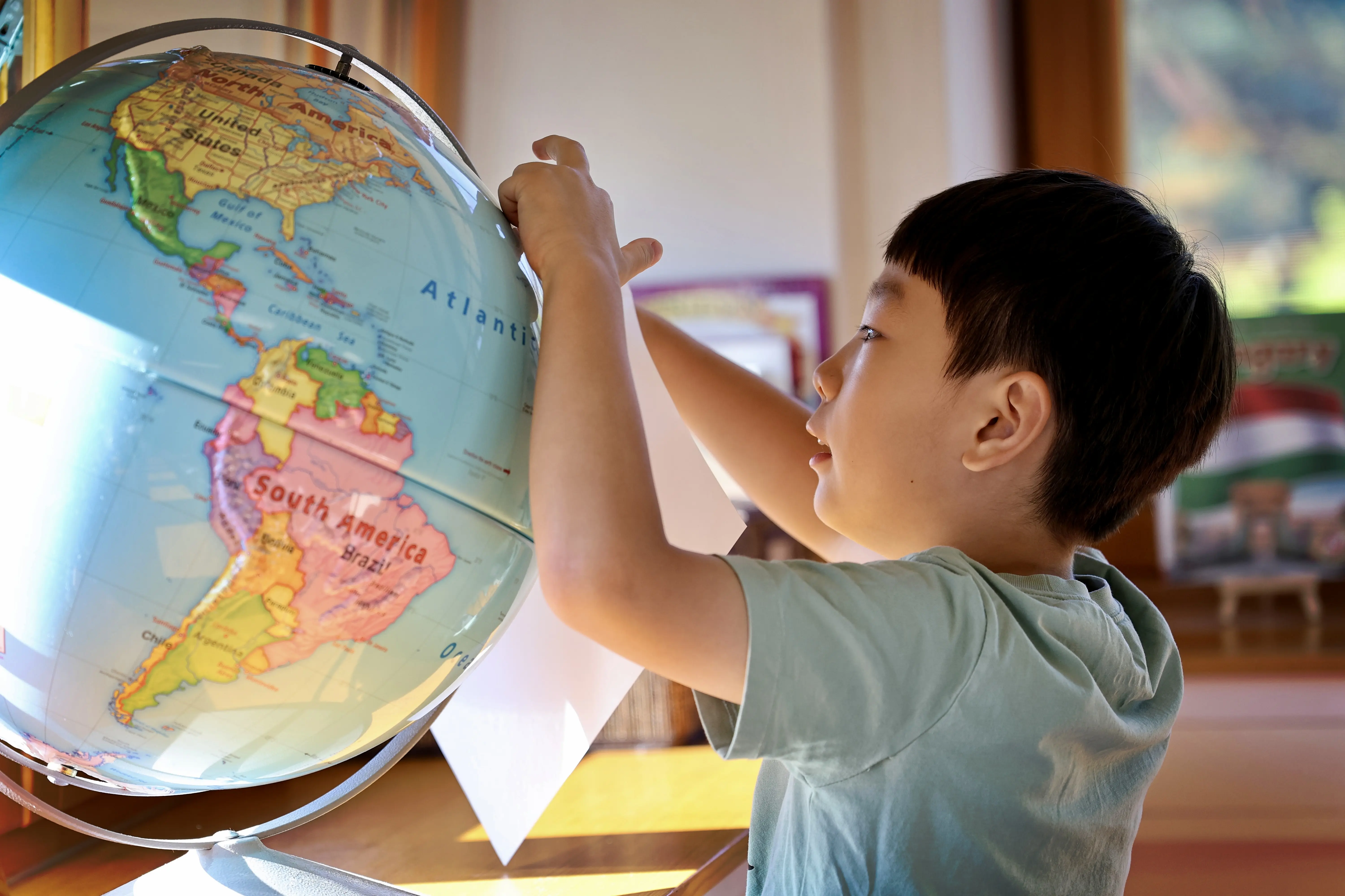 Child pointing to a globe